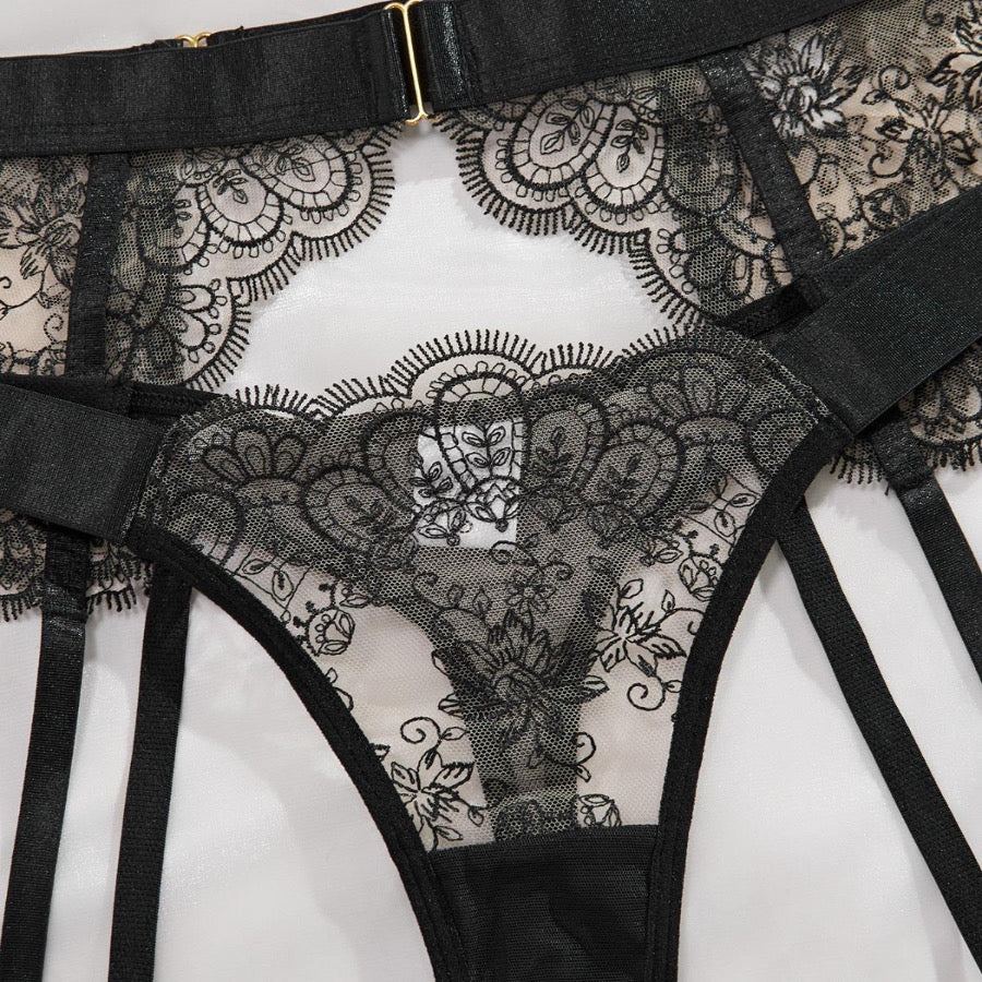 Capri Lace Lingerie Set with floral lace bra, thong and suspender belt displayed flat.